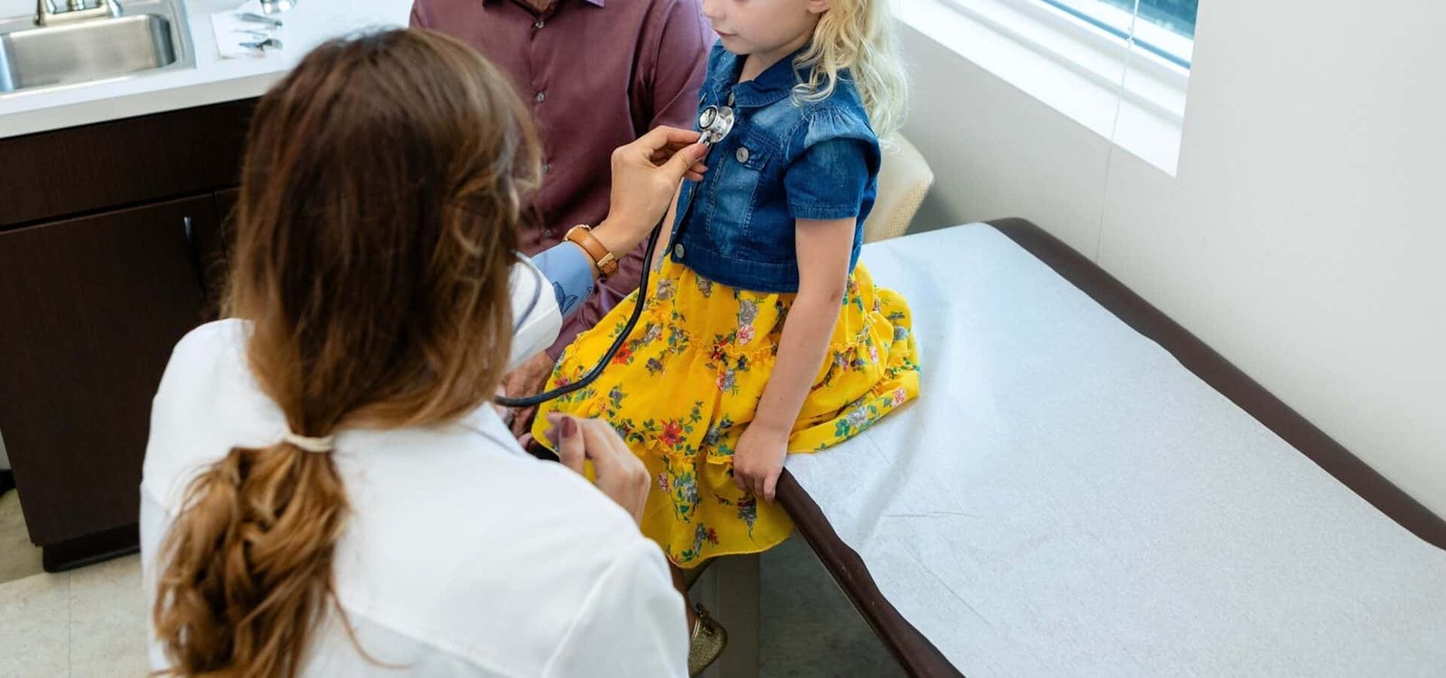 Photo: A doctor reviews a child in an office in a file photo without date. 
